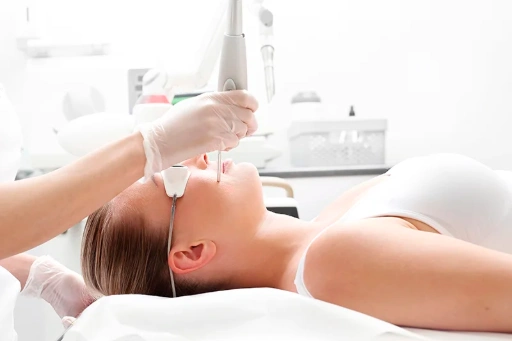 Un medico esegue una procedura di ringiovanimento laser su una donna